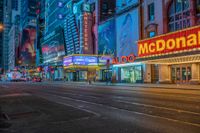 a night time view of buildings and street in the city at night with neon signs that read