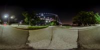 an upside down picture of an empty street at night with a bridge in the distance