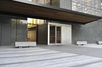 modern outdoor furniture in an empty lobby next to a door of a building with windows
