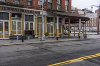 a corner cafe that is on the street side of the town, with chairs, tables and benches in front of it