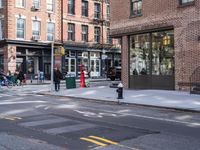 city sidewalk with people walking, traffic lights and a fire hydrant on it and a sign near the street