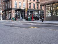 city sidewalk with people walking, traffic lights and a fire hydrant on it and a sign near the street