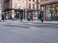 city sidewalk with people walking, traffic lights and a fire hydrant on it and a sign near the street