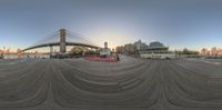 an empty boat in front of a bridge near a cityscape with skyscrapers