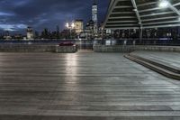 a view of new york city skyline at night from pier on the hudson river side