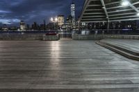 a view of new york city skyline at night from pier on the hudson river side