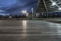 a view of new york city skyline at night from pier on the hudson river side