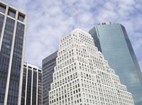 buildings in the city against a clear blue sky with clouds in the air over the city