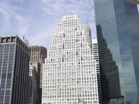 buildings in the city against a clear blue sky with clouds in the air over the city