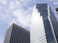 buildings in the city against a clear blue sky with clouds in the air over the city