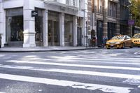 a woman wearing white and holding an umbrella crossing the street in front of a macy store
