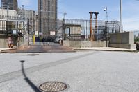 the empty urban street has some metal structures on the side of it, including a fire hydrant and manholed access
