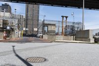 the empty urban street has some metal structures on the side of it, including a fire hydrant and manholed access