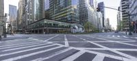 this street has a very wide crosswalk in front of some tall buildings near the intersection