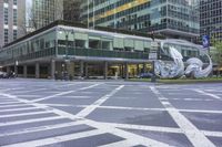 this street has a very wide crosswalk in front of some tall buildings near the intersection