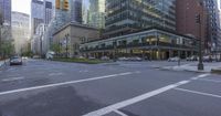 this street has a very wide crosswalk in front of some tall buildings near the intersection