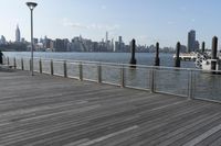 wooden deck with railing and posts in foreground and view of new york city skyline