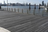 wooden deck with railing and posts in foreground and view of new york city skyline