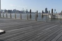 wooden deck with railing and posts in foreground and view of new york city skyline