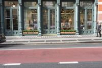 a car is on the road in front of this clothing store with a large window