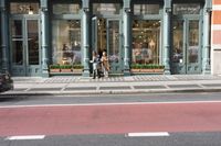a car is on the road in front of this clothing store with a large window