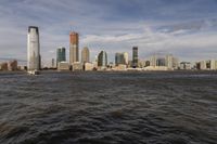 the large body of water that is close to the shore area with city buildings in the distance