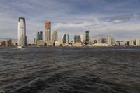 the large body of water that is close to the shore area with city buildings in the distance