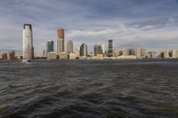 the large body of water that is close to the shore area with city buildings in the distance