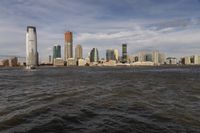the large body of water that is close to the shore area with city buildings in the distance