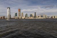 the large body of water that is close to the shore area with city buildings in the distance