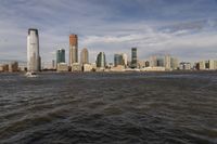 the large body of water that is close to the shore area with city buildings in the distance