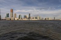 the large body of water that is close to the shore area with city buildings in the distance