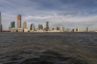 the large body of water that is close to the shore area with city buildings in the distance