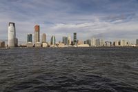 the large body of water that is close to the shore area with city buildings in the distance