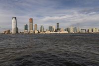 the large body of water that is close to the shore area with city buildings in the distance
