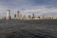 the large body of water that is close to the shore area with city buildings in the distance