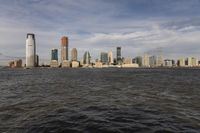 the large body of water that is close to the shore area with city buildings in the distance
