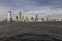 the large body of water that is close to the shore area with city buildings in the distance