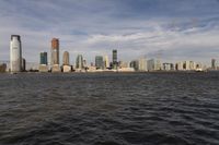 the large body of water that is close to the shore area with city buildings in the distance