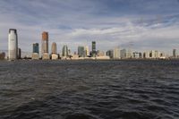 the large body of water that is close to the shore area with city buildings in the distance