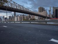 an elevated bridge crosses over the water on a cloudy day in new york city, with the empire and river bridges visible