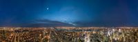 the new york city skyline at night with the moon behind it, seen from the empire building