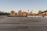 the view of a city is over the river, and the boat dock has benches and boats