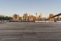 the view of a city is over the river, and the boat dock has benches and boats