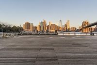 the view of a city is over the river, and the boat dock has benches and boats