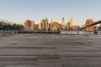 the view of a city is over the river, and the boat dock has benches and boats