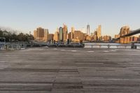 the view of a city is over the river, and the boat dock has benches and boats