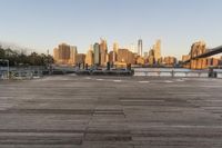 the view of a city is over the river, and the boat dock has benches and boats