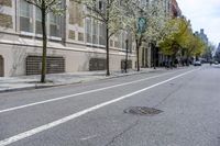 the sidewalk in front of a building with trees growing outside of it is empty,