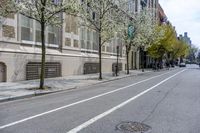 the sidewalk in front of a building with trees growing outside of it is empty,